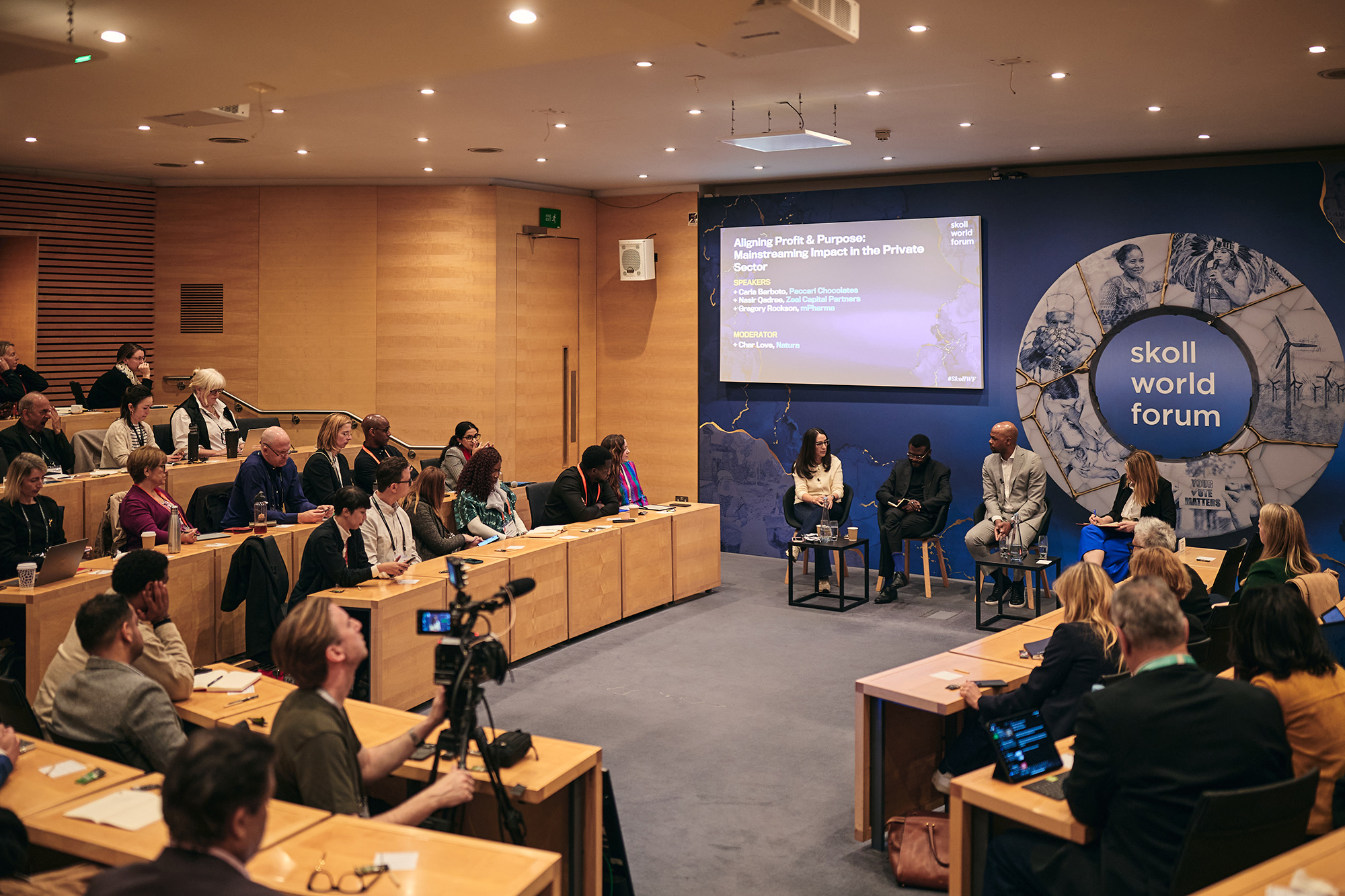 A breakout session at the Skoll World Forum 2025 with the kintsugi ring artwork on the wall and delegates seated around tables