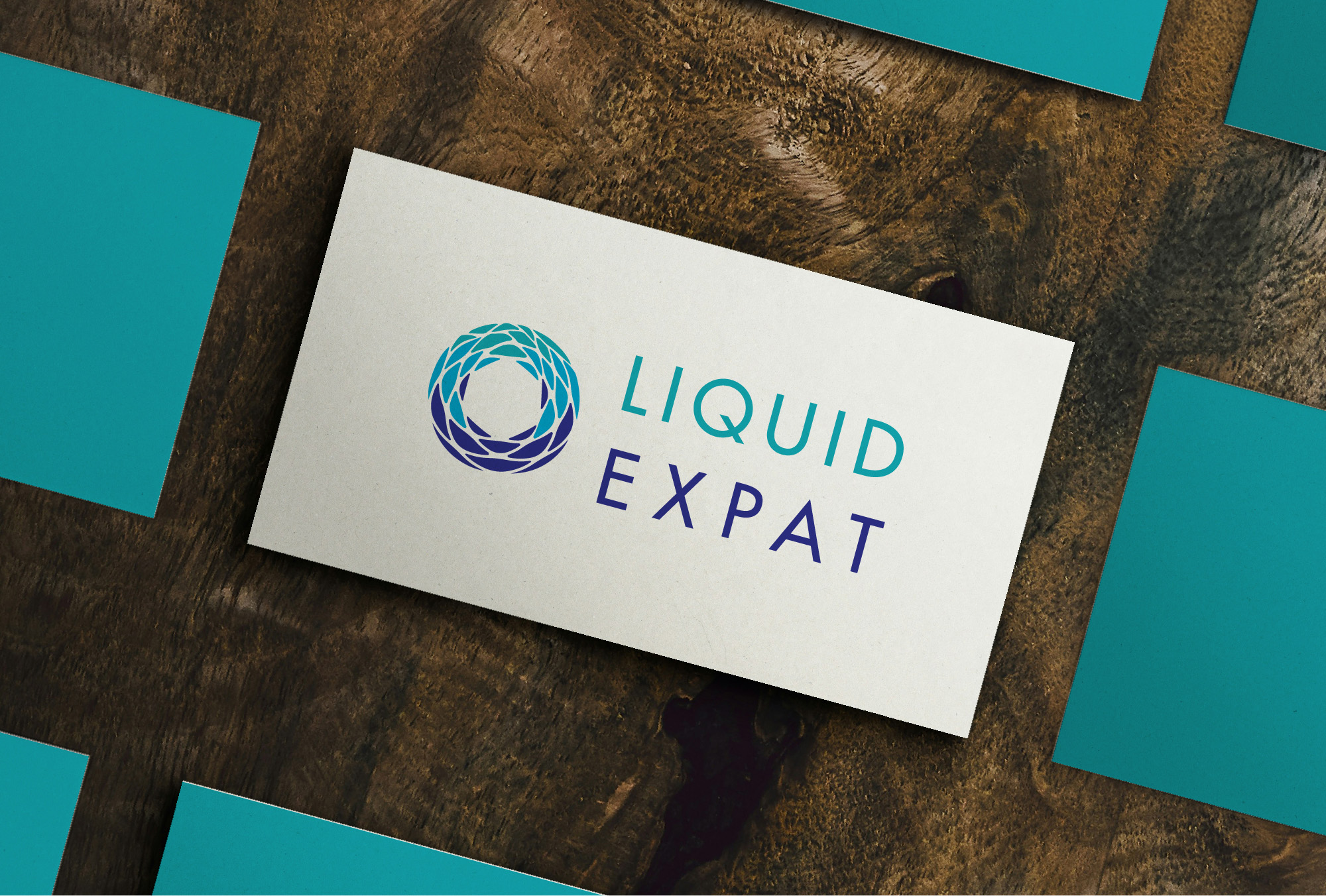 Liquid Expat entrance sign cut from brushed steel beside the turquoise and white business cards